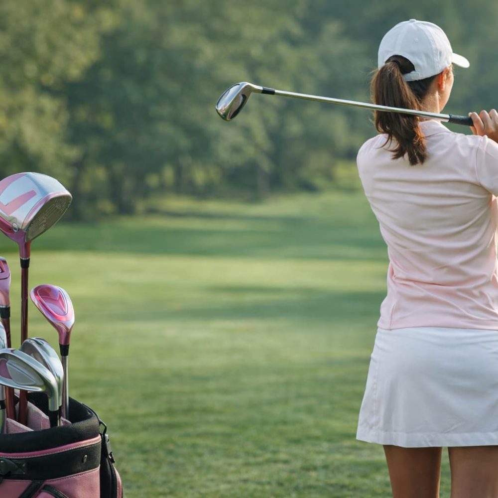 jugadora de golf con palos de golf para mujer en el campo